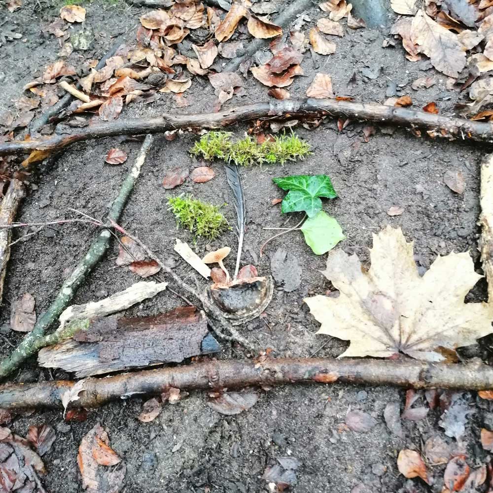 Ein mit Blättern und Zweigen gestaltetes Bild mit Rahmen